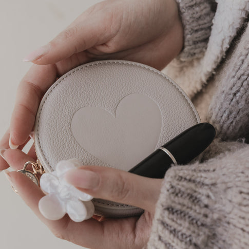 Detailaufnahme rundes Portemonnaie in Creme mit Eulenschnitt Prägung und goldenem Reißverschluss