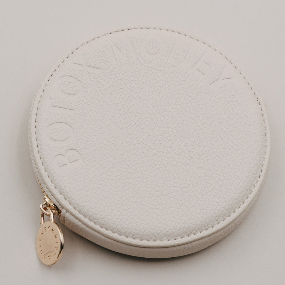 Rundes Portemonnaie in Beige mit geprägtem Schriftzug BOTOX MONEY und goldenem Reißverschlussanhänger.