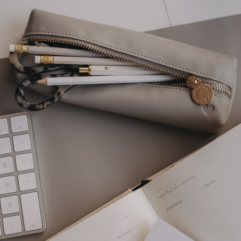 Geöffnete graue Federtasche mit Stiften und Schere, goldener Reißverschluss von Eulenschnitt