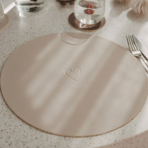 Wendbares Platzset in Beige mit geprägtem Herz auf gedecktem Tisch