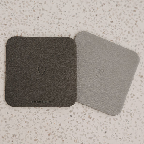 Zwei eckige Untersetzer in Hell- und Dunkelgrau mit Herzprägung von Eulenschnitt