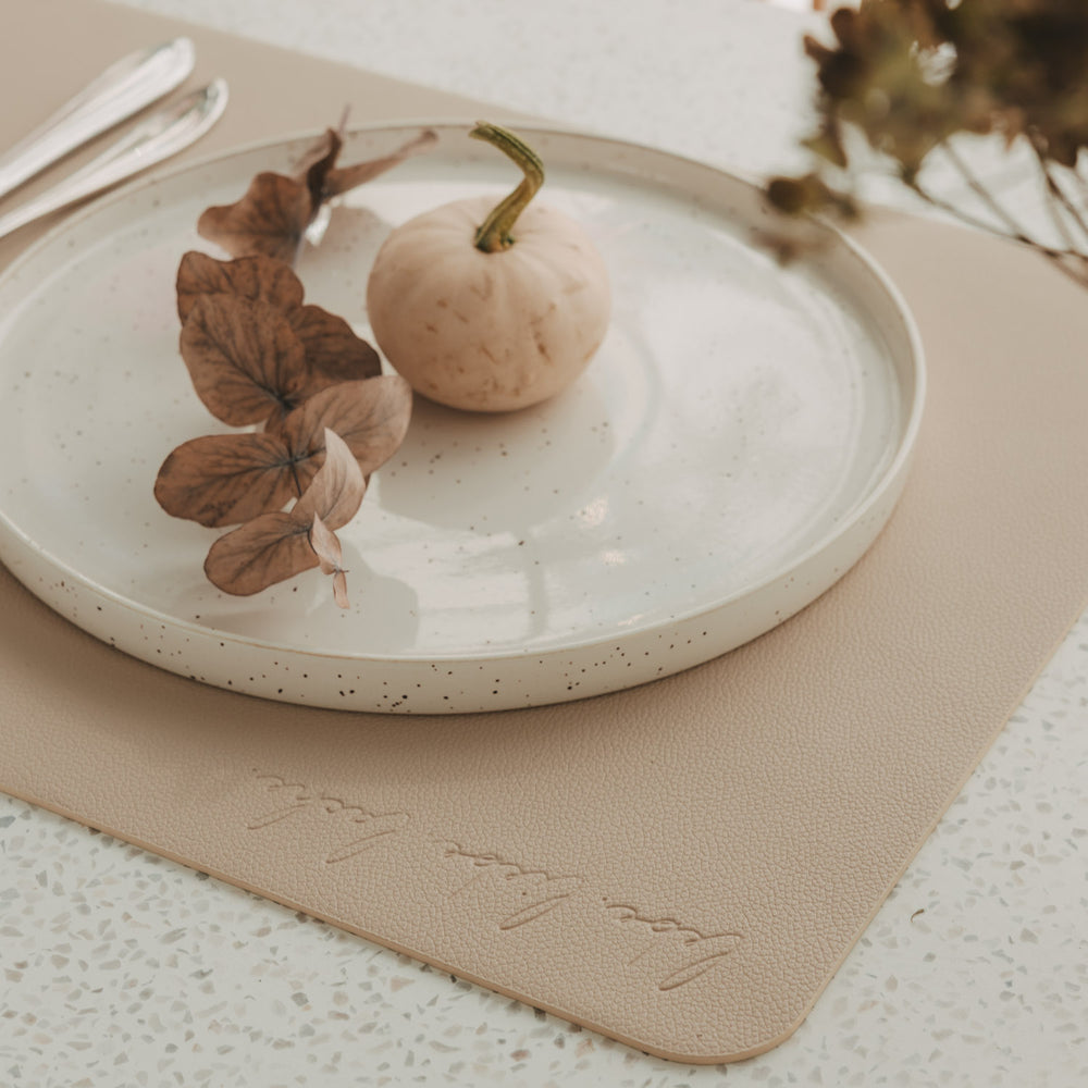 Beiges wendbares Platzset mit „lebe liebe lache“-Prägung, Teller und herbstlicher Dekoration