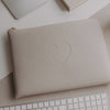 Laptophülle Taupe mit Herzprägung auf Schreibtisch neben Laptop und Tastatur