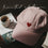 Rosa Cap mit roter Herz-Stickerei auf einem Tisch neben Kaffee und Magazin