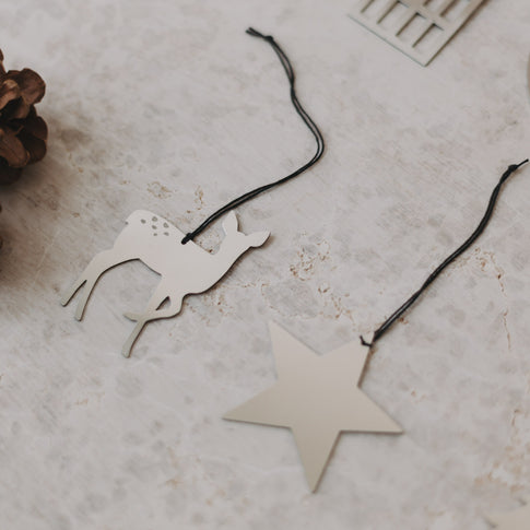 Nahaufnahme von Reh- und Sternanhänger auf hellem Untergrund