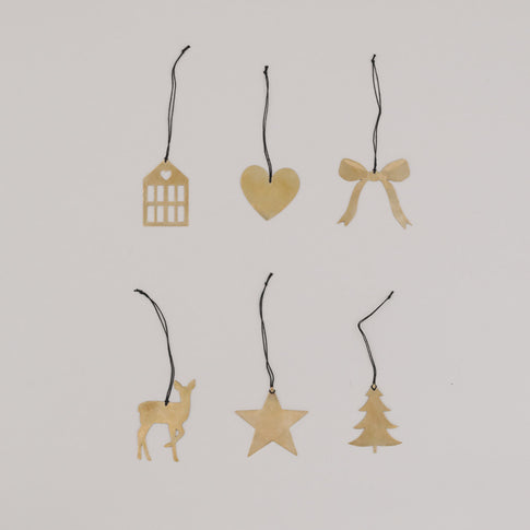 Sechs goldene Metallanhänger mit schwarzem Band in verschiedenen Formen auf hellem Hintergrund.