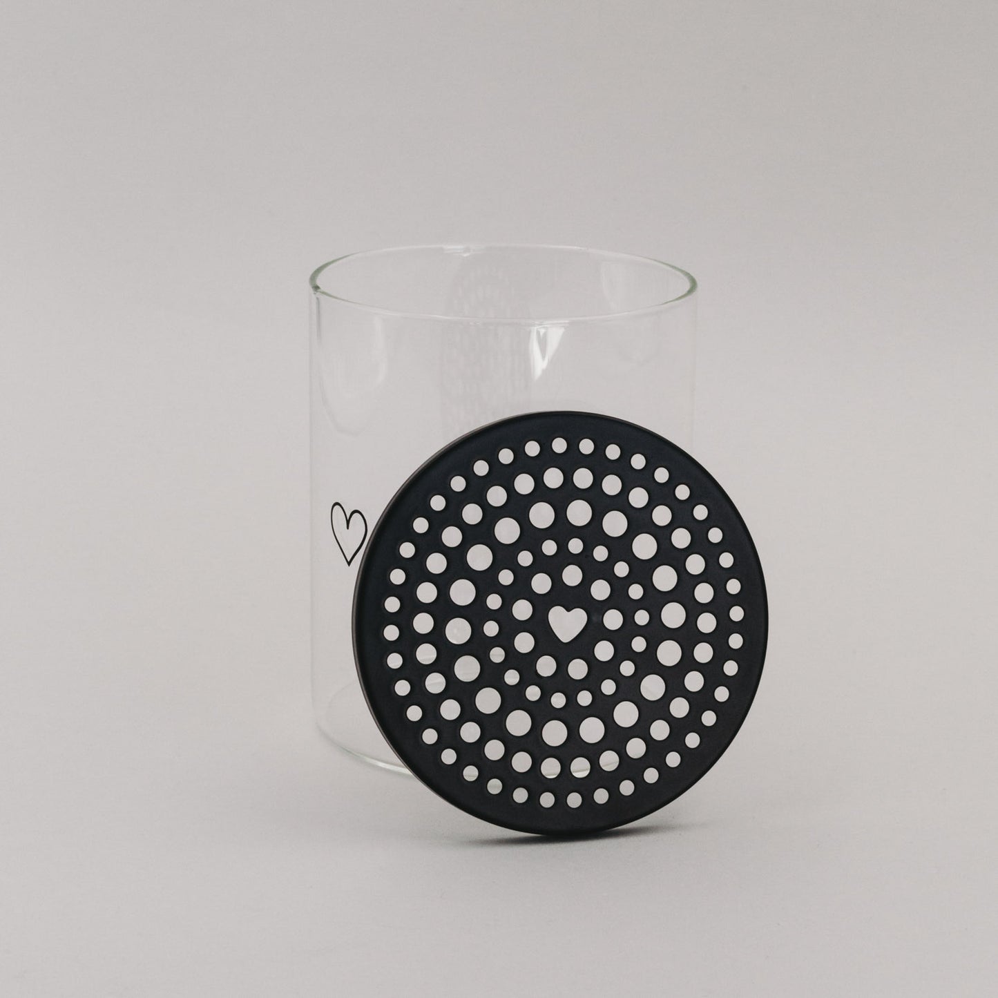 Schwarzer Blumenhalter-Deckel neben Vorratsglas – detailreiche Ansicht mit Herzloch in der Mitte
