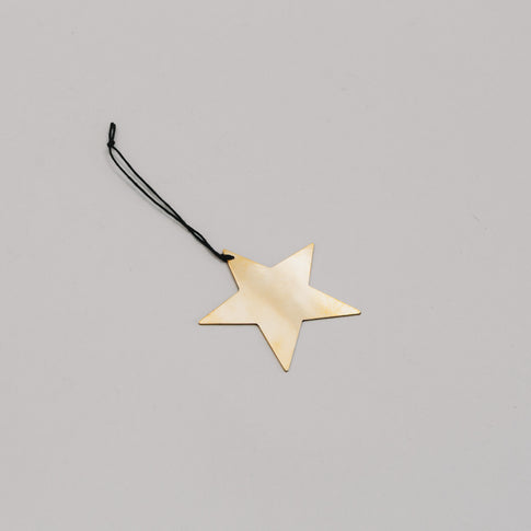 Anhänger Stern goldfarben in flacher Perspektive – filigrane Weihnachtsdeko aus Metall mit schwarzem Band.