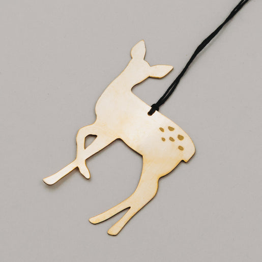 Detailaufnahme vom goldenen Metallreh mit schwarzer Schnur, zeigt reflektierende Oberfläche.