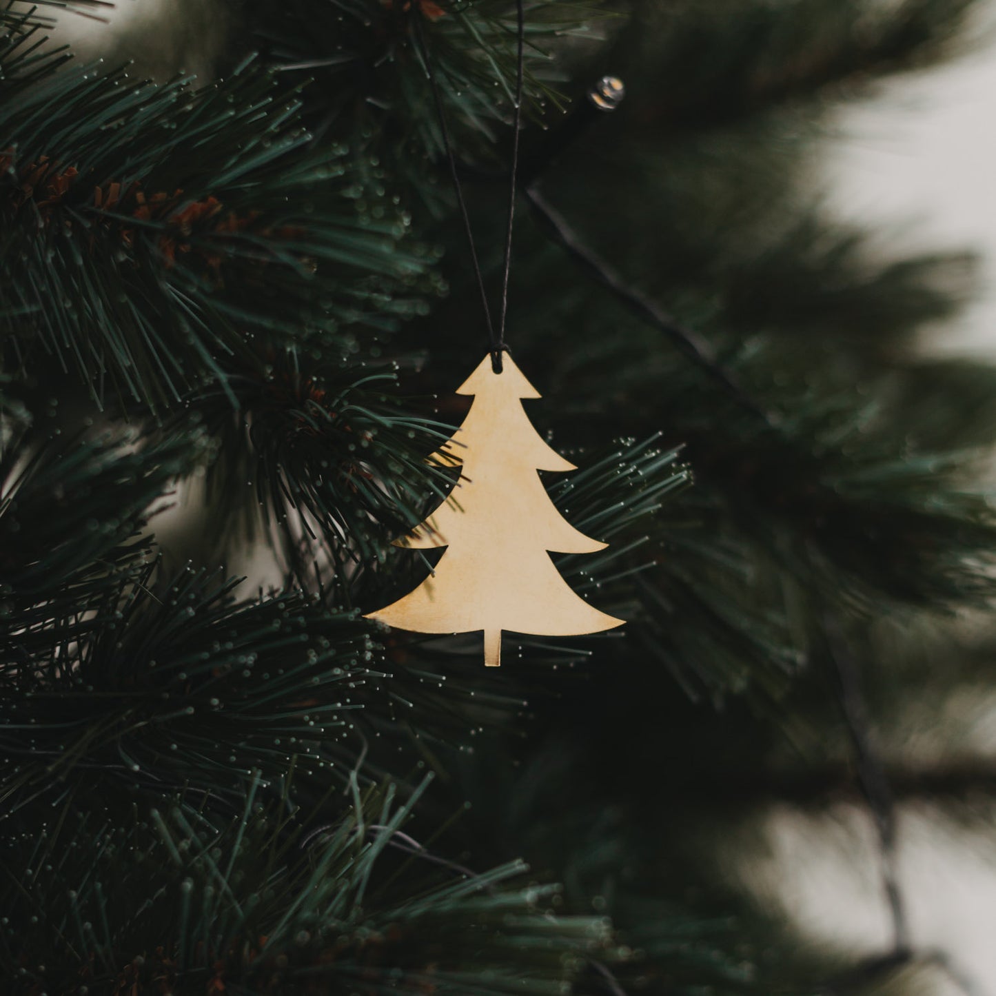 Glänzender goldener Tannenanhänger am Weihnachtsbaum.