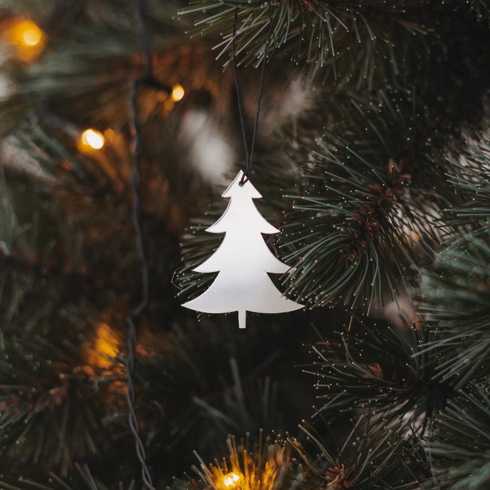 Glänzender silberner Tannenanhänger am Weihnachtsbaum.