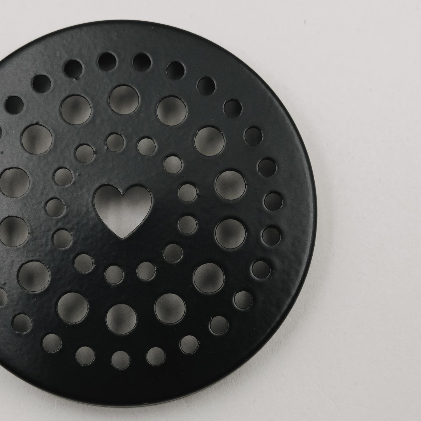 Detailaufnahme des schwarzen Lochdeckels mit Herz-Ausschnitt für den Mini-Blumenhalter von Eulenschnitt.