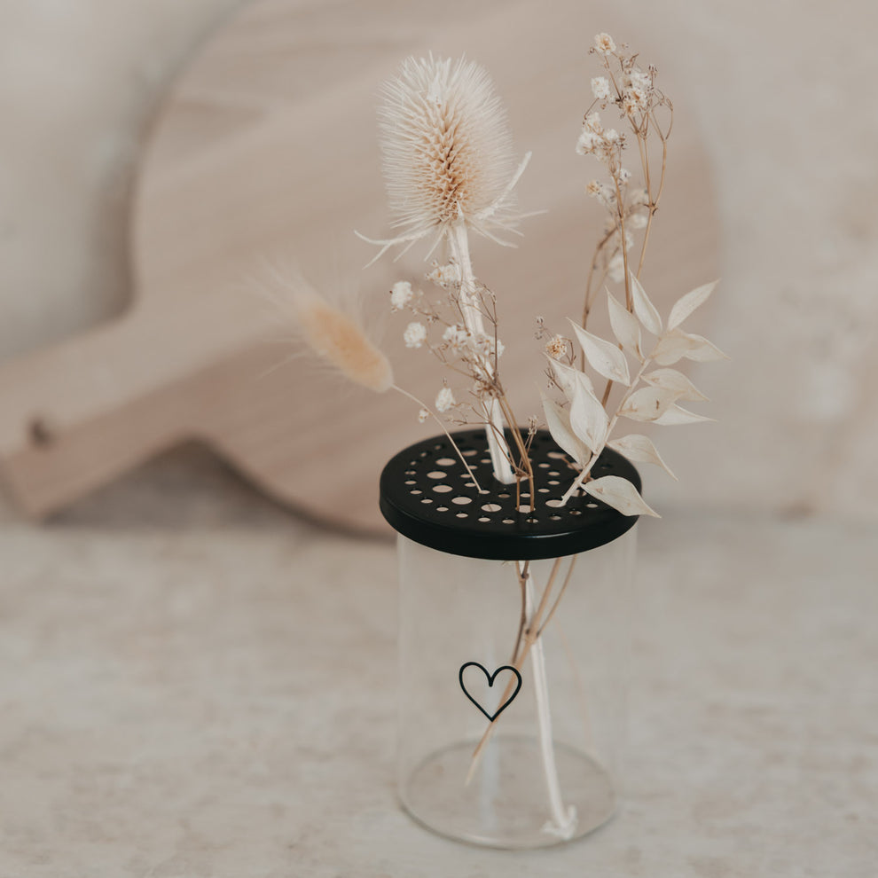 Mini-Blumenhalter aus Glas mit schwarzem Deckel und Trockenblumen, verziert mit Herzmotiv von Eulenschnitt.