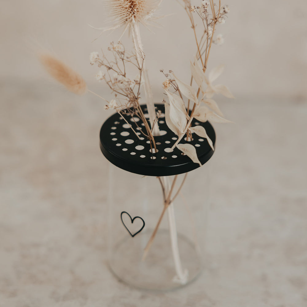 Glas-Blumenhalter mit schwarzem Lochdeckel und Trockenblumen, minimalistisches Herzdesign von Eulenschnitt.