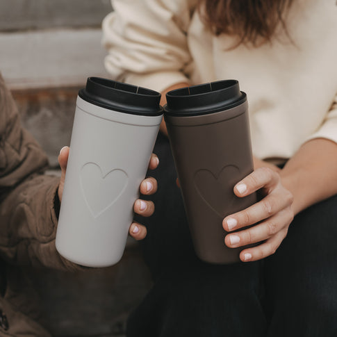 Grauer und brauner To-go-Thermobecher mit Herzmotiv und schwarzem Deckel