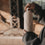 Nahaufnahme einer cremefarbenen Trinkflasche mit Herzmotiv, während eine Frau den Schraubverschluss öffnet.