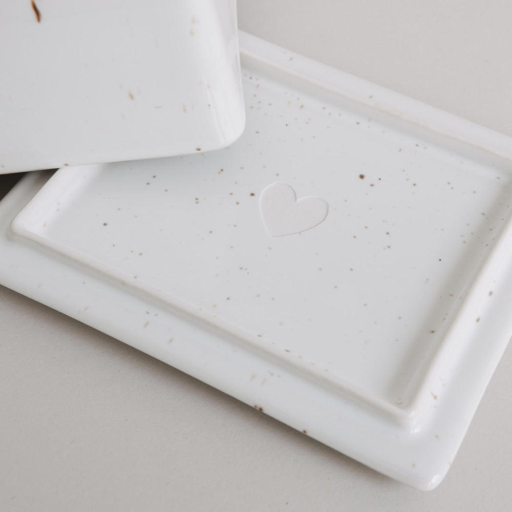 Detail Butterdose mit Herz-Prägung, weiße Keramik mit feinen Sprenkeln, schlichtes Design