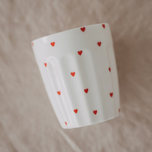 Weißer Becher mit kleinen roten Herzen, modernes minimalistisches Design