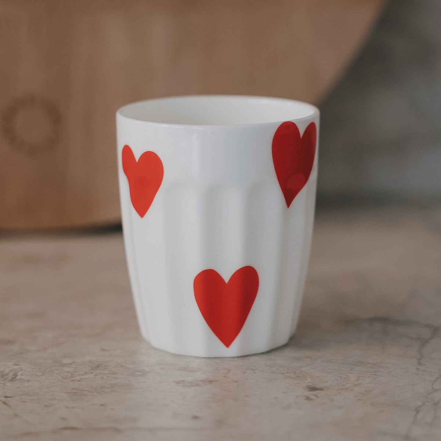 Weißer Keramikbecher mit roten Herzmotiven, modernes schlichtes Design