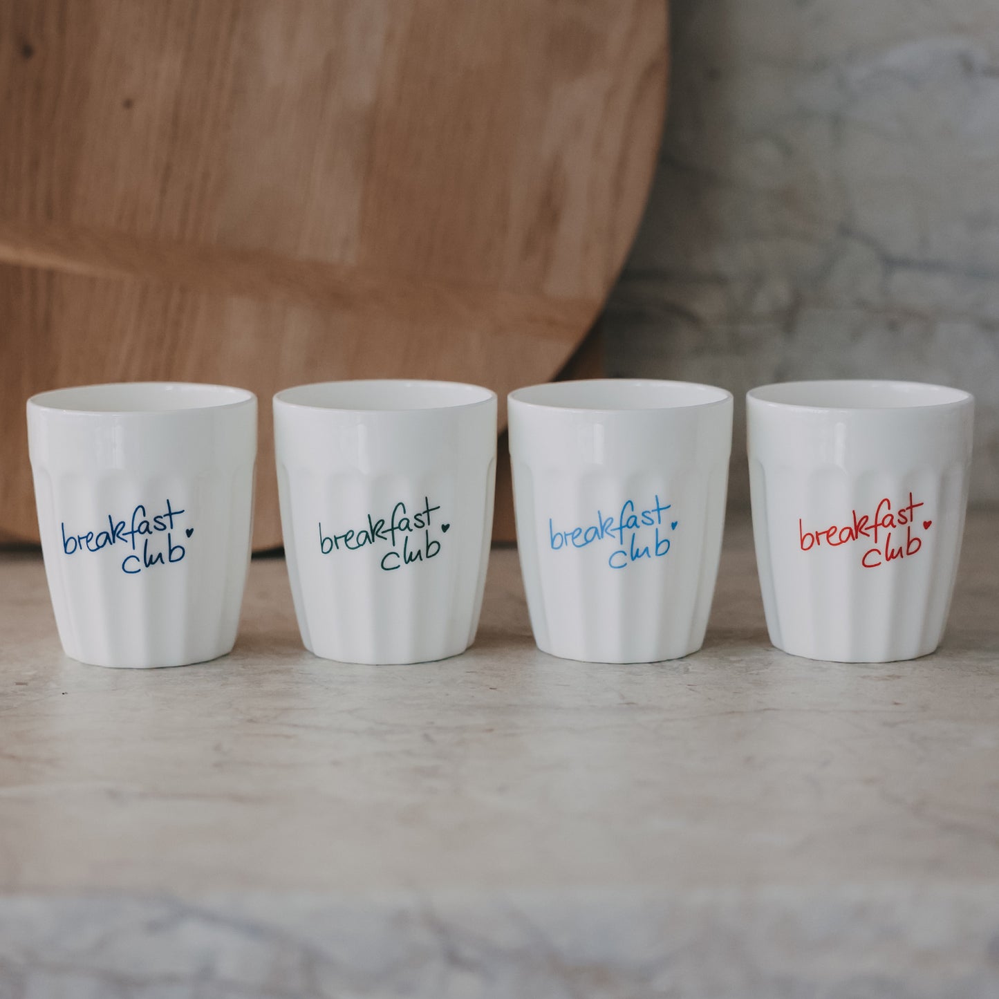 Vier weiße Keramikbecher mit „breakfast club“ Schriftzug in verschiedenen Farben