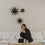 Schwarze Papiersterne mit Lichterkette als minimalistische Weihnachtsdeko über weißem Sofa