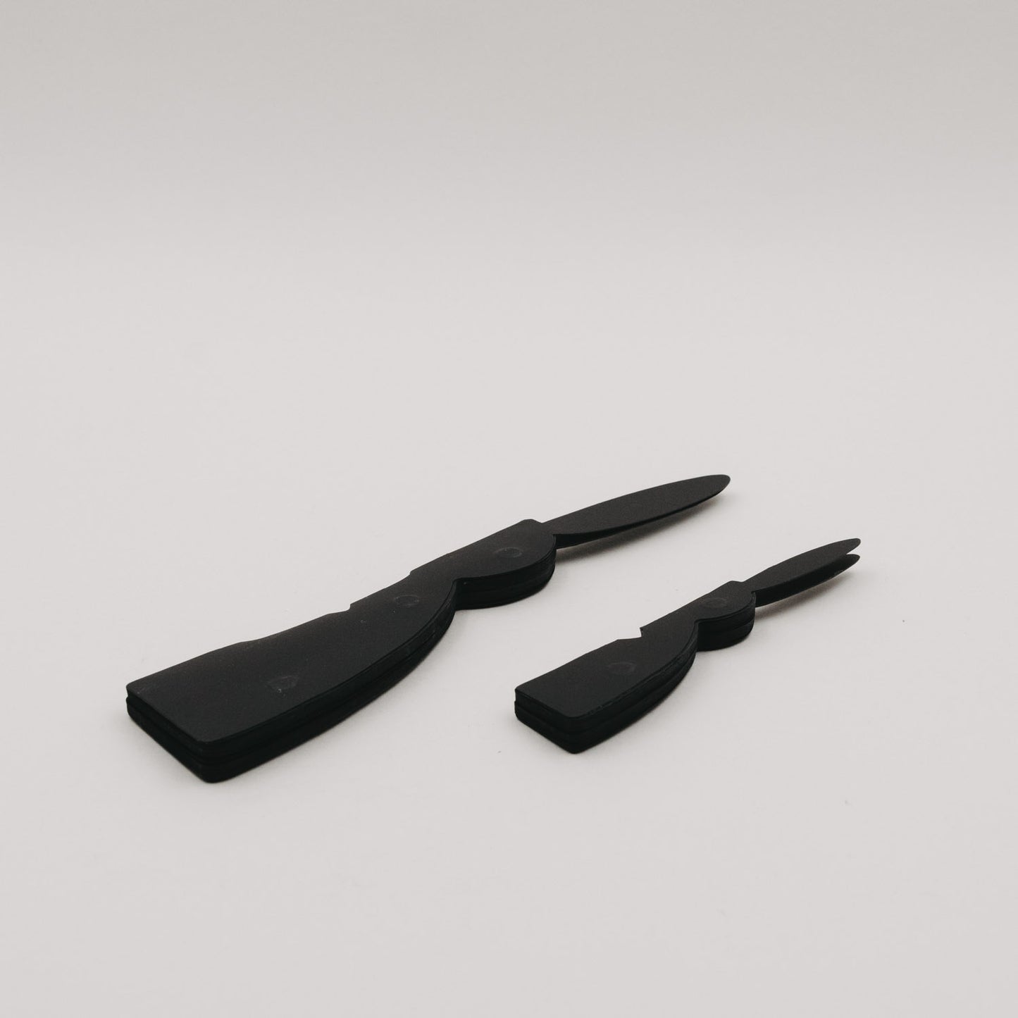 Zwei flache Papierhasen in Schwarz im ungefalteten Zustand als Deko-Set.