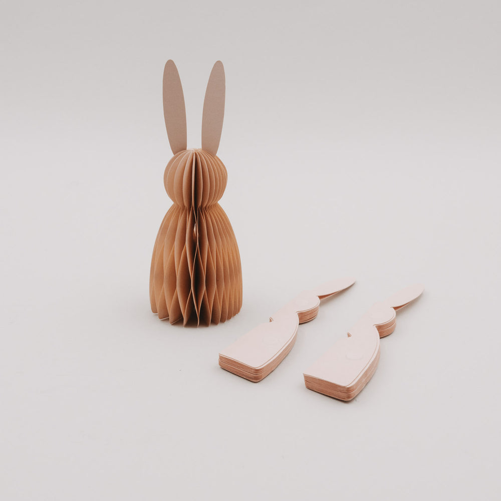 Ein peachfarbener Papierhase und zwei flache Einzelteile des 3er-Sets von Eulenschnitt.