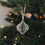 Grauer Weihnachtsanhänger in Kugelform aus Papier am Tannenbaum
