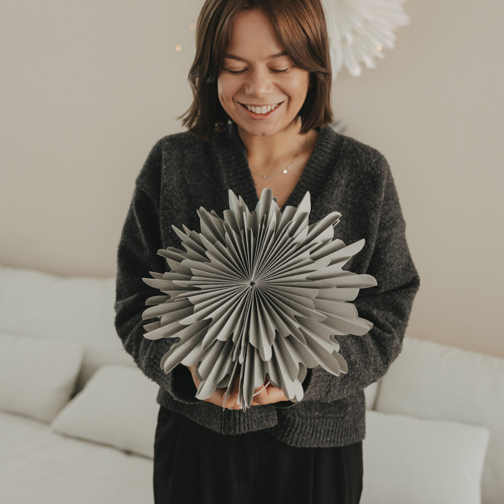 Graue Papierschneeflocke 30 cm wird als Weihnachtsdekoration präsentiert