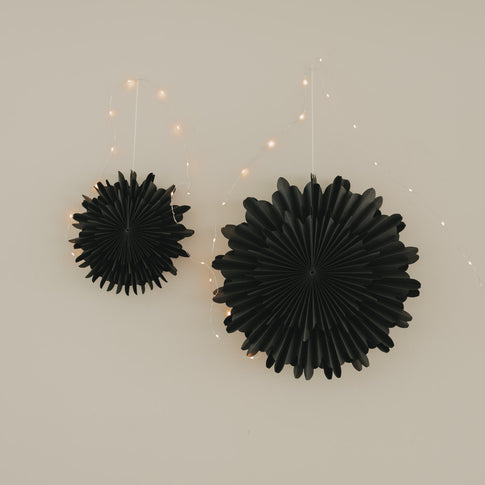 Schwarze Papierschneeflocken als elegante Weihnachtsdekoration mit filigraner Fächerstruktur