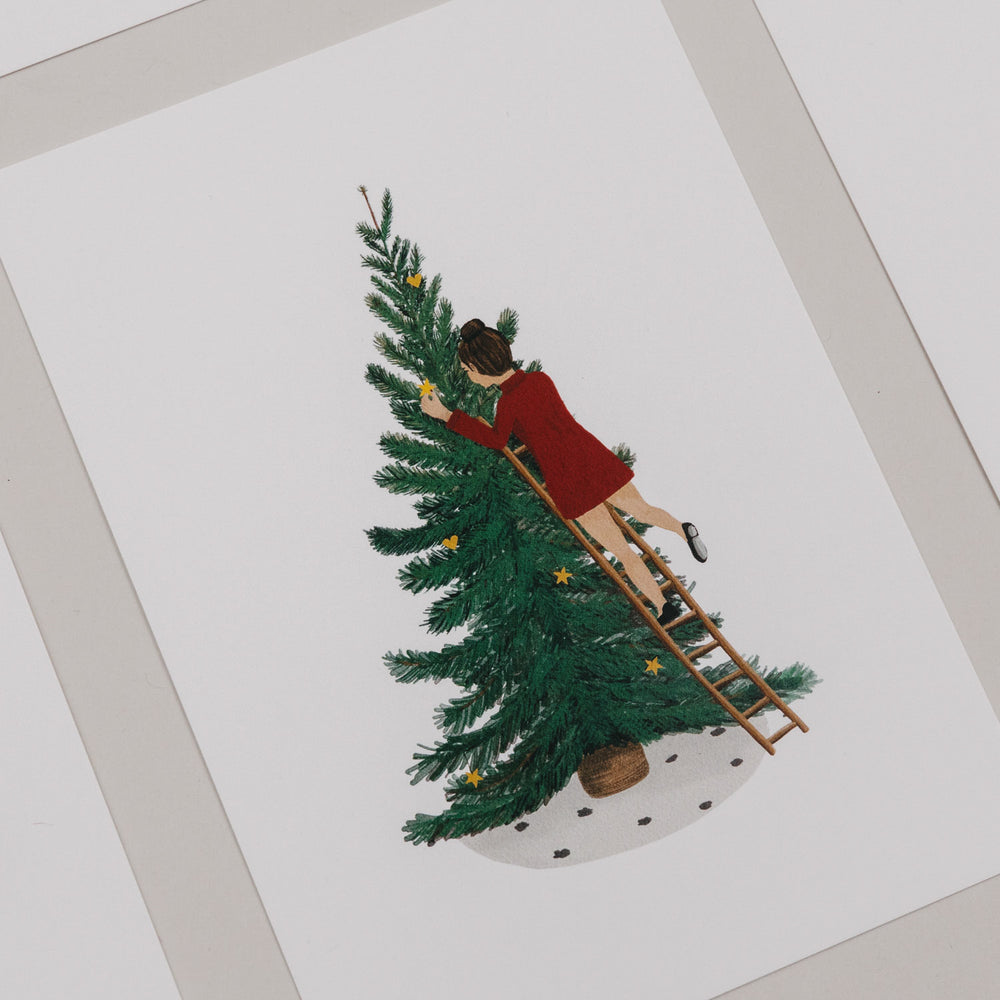 Weihnachtskarte mit Illustration einer Frau, die einen Tannenbaum mit Sternen dekoriert