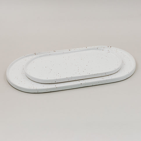 Zwei Servierplatten Calma in klein und groß aus Steingut mit feinem Sprenkelmuster im Größenvergleich