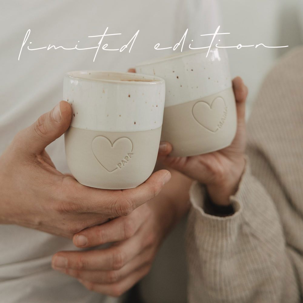 Detailaufnahme Keramikbecher Papa und Mama mit Herzprägung, in Händen gehalten