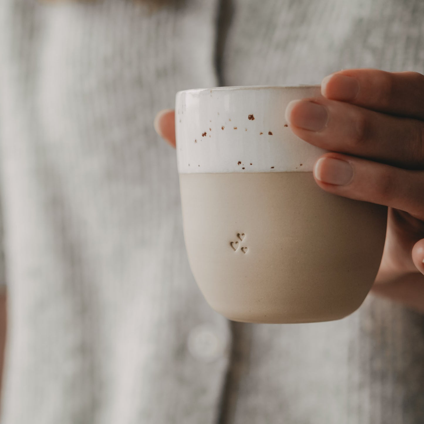Hand hält Keramik Becher mit kleinen Herzen, stilvoller Mini Mug für Kaffee oder Tee