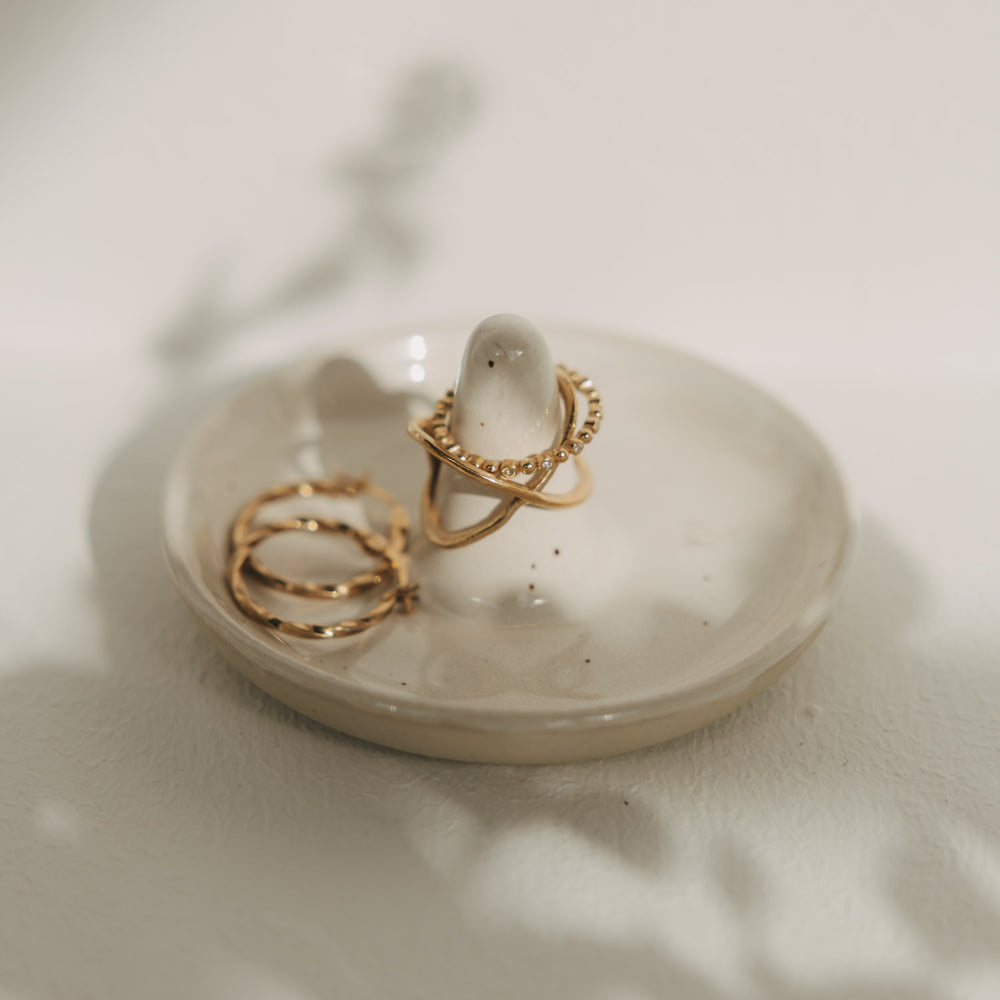 Schmuckablage aus Keramik mit Ringhalter und goldenen Ringen