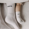 Kuschelige Familienmomente mit Papa- und Mini-Socken auf weichem Bett.