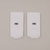 Flachliegende weiße Socken mit „MR“ Schriftzug in minimalistischer Darstellung