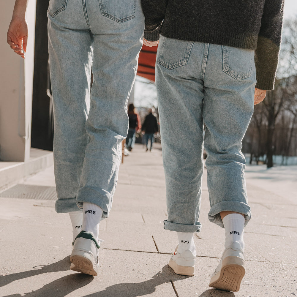 Zwei Personen mit weißen „MRS“ Socken gehen gemeinsam auf Straße