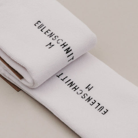 Gefaltete weiße Socken „MRS“ mit Eulenschnitt Branding im Detail