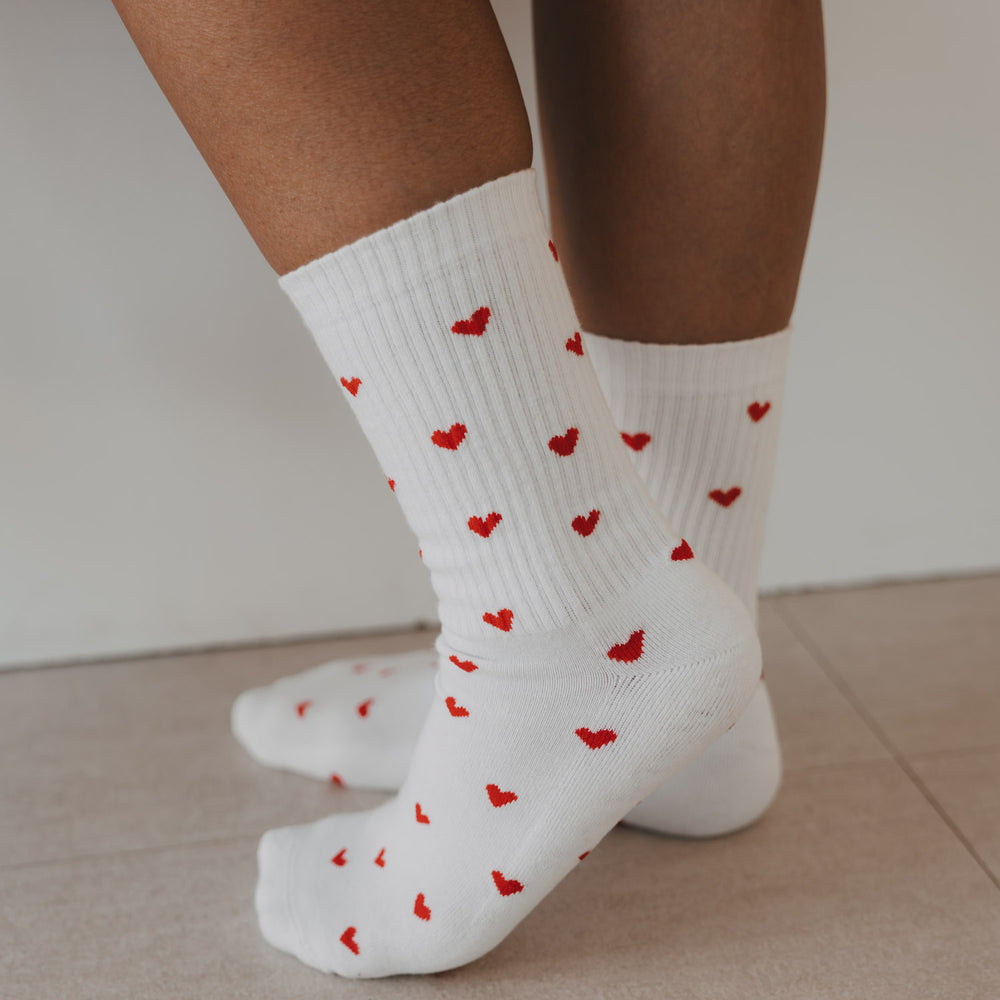 Detailansicht der weißen Eulenschnitt Socken mit roten Herzen im Allover-Design.