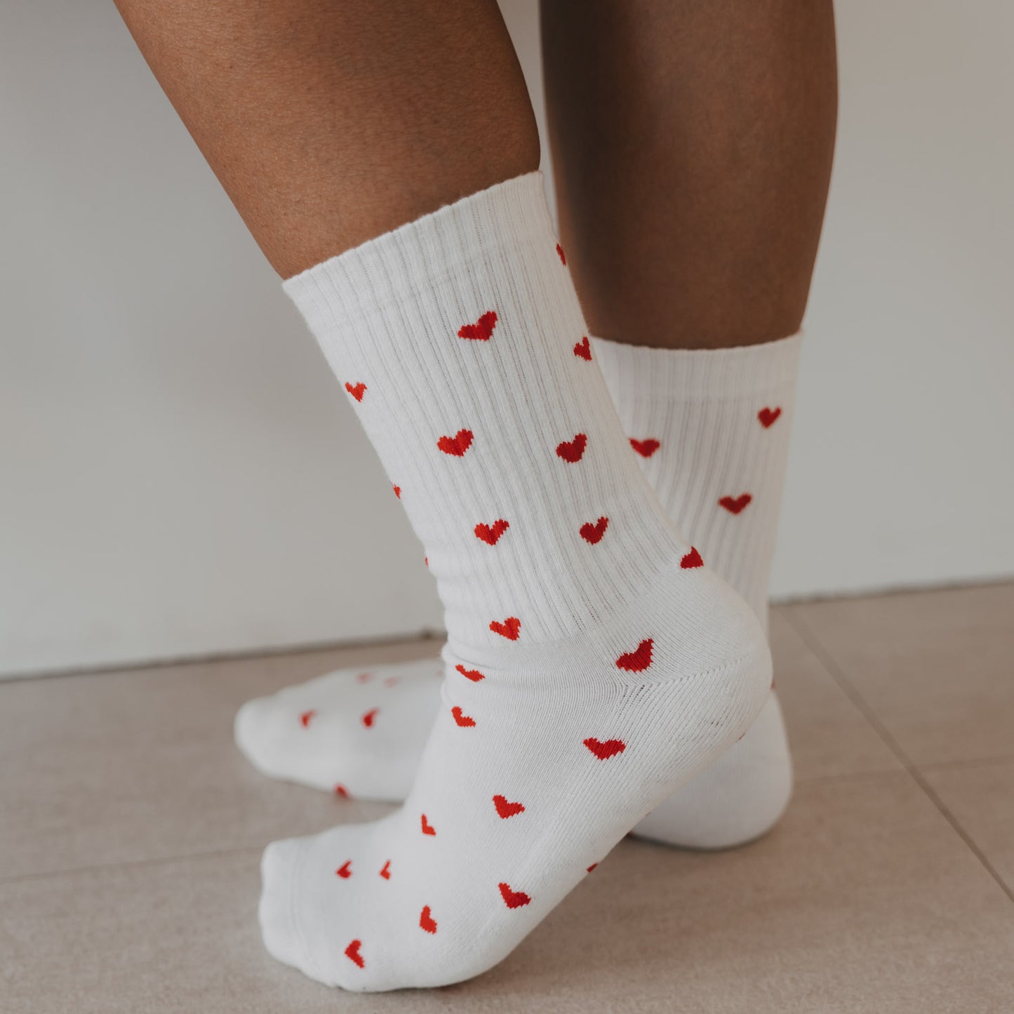 Detailansicht der weißen Eulenschnitt Socken mit roten Herzen im Allover-Design.