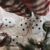 Weiße Eulenschnitt Socken mit grünen Tannen für Erwachsene und Kinder in weihnachtlicher Atmosphäre.