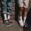 Zwei Kinder tragen weiße Eulenschnitt Socken mit roten Herzen und Sneaker.