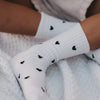 Nahaufnahme der weißen Kids Socken mit schwarzem Herzmuster von Eulenschnitt
