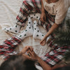 Familie trägt weiße Eulenschnitt Socken mit grünen Tannen zur Weihnachtszeit