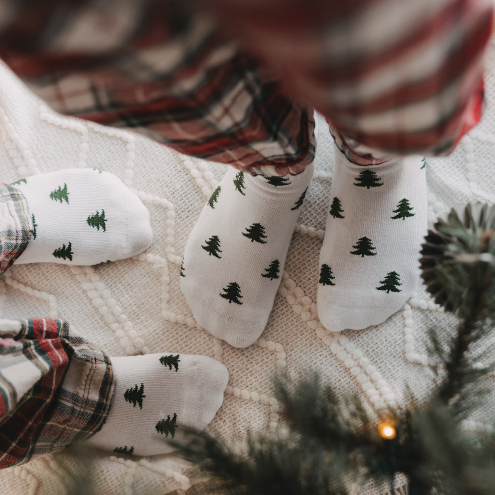 Nahaufnahme weißer Kids Socken mit grünen Tannen von Eulenschnitt