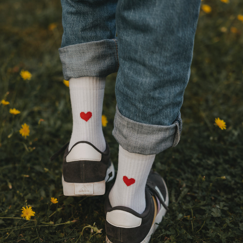 Kind trägt weiße Socken mit rotem Herz von Eulenschnitt im Grünen