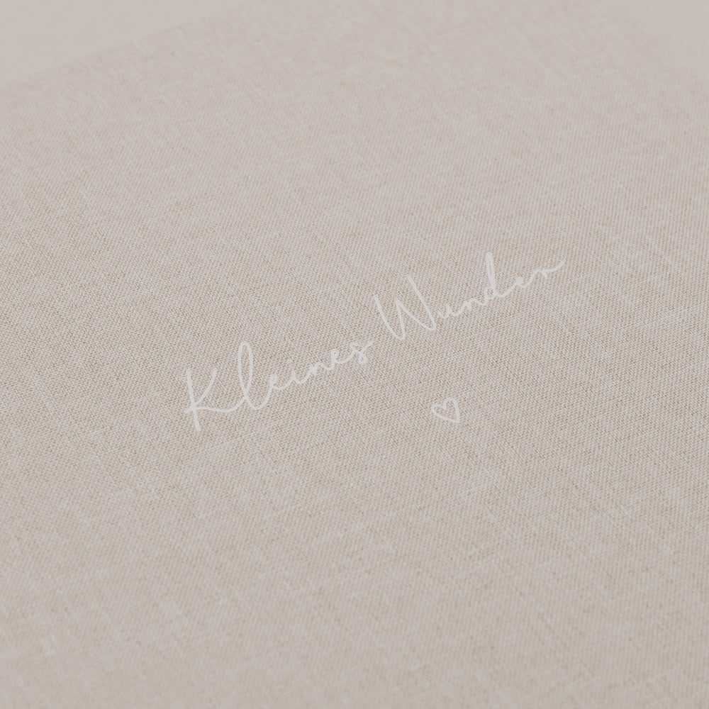 Nahaufnahme der geprägten Schrift „Kleines Wunder“ auf dem Stoffeinband.