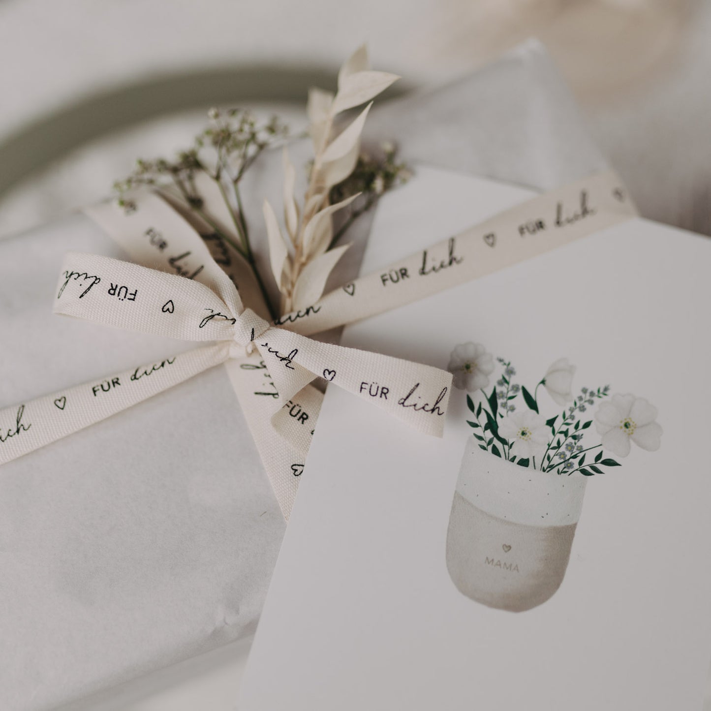 Geschenk mit weißem Geschenkband „Für dich“ und Grußkarte dekoriert.
