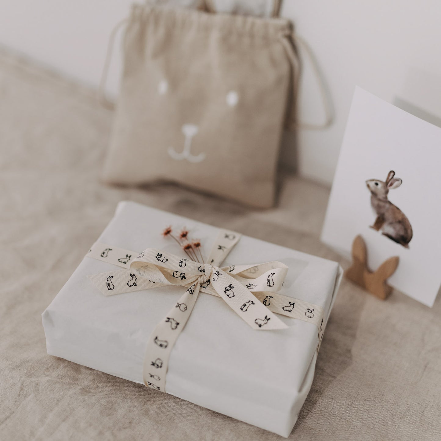 Eingepacktes Geschenk mit Kaninchen-Geschenkband vor Beutel und Hasenkarte.